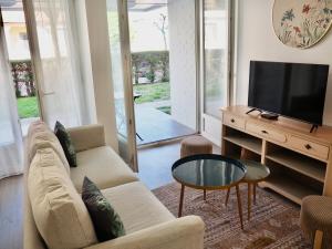 a living room with a couch and a tv and a table at Appart T2 cabine 5 min du centre in Le Touquet-Paris-Plage