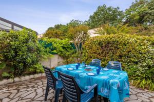 un tavolo con una tovaglia blu seduto su un patio di Maison aux Oiseaux - Welkeys a Dolus-d'Oléron