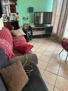 a living room with a couch and a flat screen tv at Casa top in Ribeirão Preto