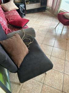 a black couch with pillows on a tile floor at Casa top in Ribeirão Preto