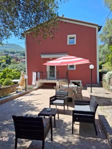 a patio with chairs and a table and an umbrella at Casa Vacanze VERDE MARE RELAX in La Spezia