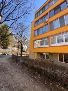 an orange building on the side of a street at Linen Tree Apartment in Băile Herculane