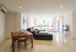 ein Wohnzimmer mit einer Couch und einem Tisch und Stühlen in der Unterkunft Holiday Homes At Samsuria Resort in Kampung Sungai Ular