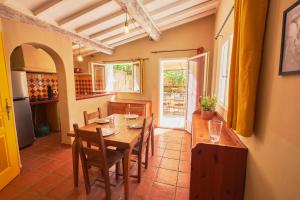 a dining room with a wooden table and chairs at Maison provençale avec jardin in Velleron