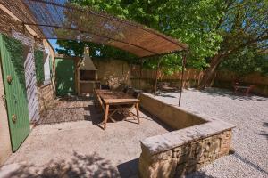 a backyard with a wooden table and a grill at Maison provençale avec jardin in Velleron