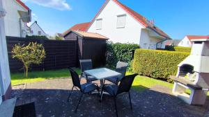 a patio with a table and chairs in a backyard at Ferienwohnung Plogmann - Residenz Bernstein WHG 39 in Rerik