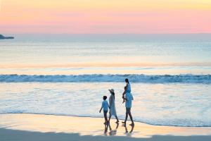 a group of people walking on the beach at InterContinental Bali Resort by IHG in Jimbaran