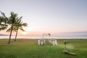 a wedding ceremony on the beach with a palm tree at InterContinental Bali Resort by IHG in Jimbaran