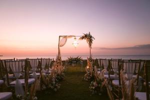 a wedding ceremony on the beach at sunset at InterContinental Bali Resort by IHG in Jimbaran
