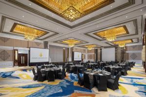 a banquet hall with tables and chairs and a projection screen at InterContinental Bali Resort by IHG in Jimbaran