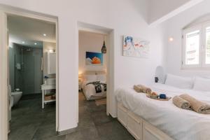 a white bedroom with two beds and a bathroom at Aegean Nest in Koskinou +81 photos