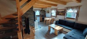 a living room with a blue couch and a stone fireplace at Chalets Barbora and Michal in Závažná Poruba