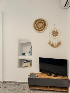 a living room with a flat screen tv on a white wall at Porto Gavrio Apartment in Gavrion