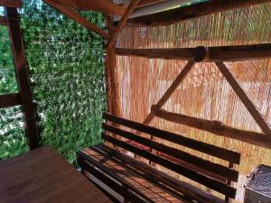 a room with a wooden bench in a straw hut at Apartman Retro in Žepče