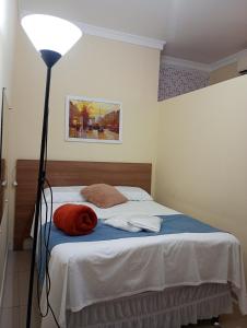 a bedroom with a bed with a lamp next to it at Kitnet linda 8A in Montes Claros +6 photos