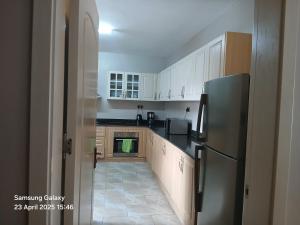 a kitchen with white cabinets and a stainless steel refrigerator at The Hideout in Nairobi +8 photos