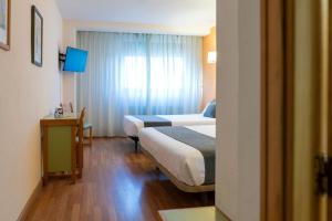 A bed or beds in a room at Hotel Alda Guijuelo