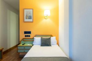 A bed or beds in a room at Hotel Alda Guijuelo