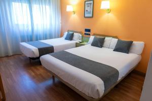 A bed or beds in a room at Hotel Alda Guijuelo