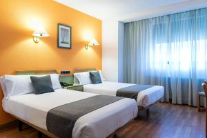 A bed or beds in a room at Hotel Alda Guijuelo