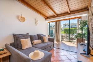 a living room with a couch and a tv at The Golden Breeze – Beachside Pool & BBQ Escape in Faro