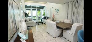 a living room with a table and white chairs at Sea Breeze Villa in Fajardo +25 photos