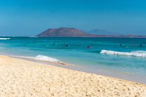 a group of people in the water at the beach at Villa Stars Seaview Corralejo in Corralejo
