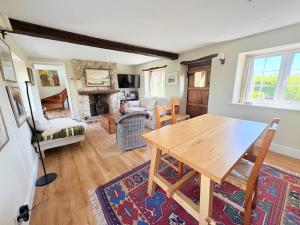 ein Wohnzimmer mit einem Holztisch und einem Kamin in der Unterkunft Charming modernized country cottage Near Mere, Wiltshire in Mere