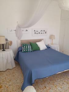 a bedroom with a blue bed with pillows on it at Villetta Rosetta in Capri