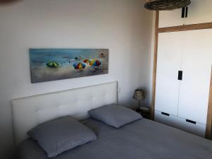 sypialnia z łóżkiem i obrazem na ścianie w obiekcie LE BORD de MER w Calais