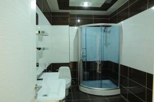 a bathroom with a toilet and a glass shower at Arena Hotel Dashkasan in Xoşbulaq +16 photos