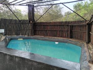 a swimming pool in front of a wooden fence at Kifaru - Kruger in Marloth Park