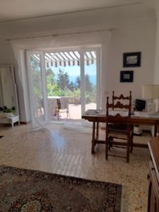 a living room with a table and a view of a patio at Villetta Rosetta in Capri +46 photos