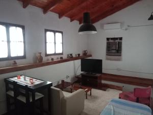 a living room with a table and a television at Mikasa in La Porteña
