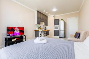 a white bedroom with a white bed and a refrigerator at Nexpo city apartments near Expo in Stroitelʼnyy