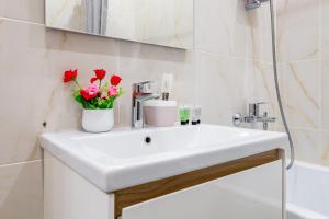 a bathroom with a white sink with flowers on it at Nexpo city apartments near Expo in Stroitelʼnyy +18 photos