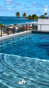 a swimming pool with the ocean in the background at ORA Beach Residence by AFT in Porto De Galinhas
