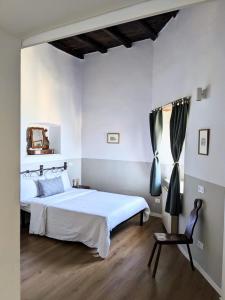 a bedroom with a white bed and a chair at Alcova delle Arvolte in Narni