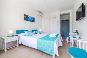 1 dormitorio con 1 cama, 2 mesas y TV en Panorama by Youroom, en Puerto Pollensa