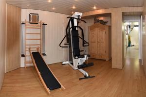 Un gimnasio con una cinta de correr y una cinta de correr en una habitación. en Appartementhaus Parzer, en Pruggern 17 fotos más