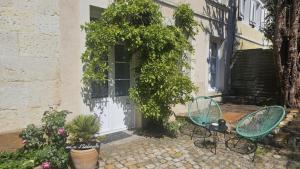 two chairs and a table in front of a door at L'Écrin Love Room Spa privatif Orbec in Orbec-en-Auge