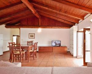 a living room with a table and chairs and a television at Appartamento Dante in Moniga
