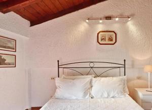 a bedroom with a black bed with white pillows at Appartamento Dante in Moniga +3 photos