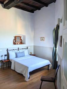 a bedroom with a bed and a chair in it at Alcova delle Arvolte in Narni