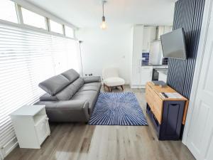 a living room with a couch and a tv at 104 The Laurels in Skegness