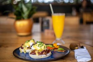 a plate of food on a table with a glass of orange juice at Tugende Hostel in Kigali +27 photos