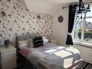 a bedroom with a bed and a wall with birds on it at Lilac Villa Skegness in Skegness