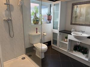 a bathroom with a toilet and a sink and a shower at Lilac Villa Skegness in Skegness +28 photos