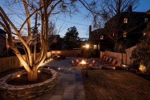 un patio con sillas y un árbol por la noche en The Royce - Two Luxury Family Homes in Downtown Newport, en Newport