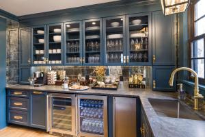 Una cocina azul con una barra con botellas de vino. en The Royce - Two Luxury Family Homes in Downtown Newport, en Newport
